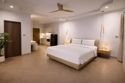 a bedroom with a large white bed and a bathroom at The Escape Kamala in Kamala Beach