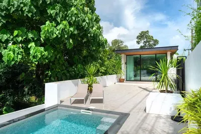 a swimming pool in a garden with a house at Villa Heaven in Kata Beach