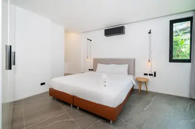 a bedroom with a large white bed and a table at Villa Heaven in Kata Beach