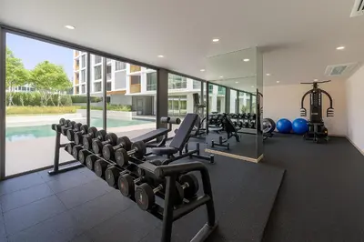 an indoor gym with treadmills and a swimming pool at The Ozone Condominium 2 bedroom by Search Estate in Phuket Town