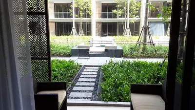 a view of a garden with benches in a building at Baan Mai Khao Beach Residence in Mai Khao Beach