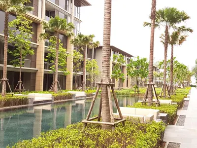 a view of a building with palm trees in front at Baan Mai Khao Beach Residence in Mai Khao Beach