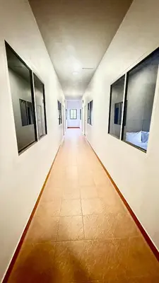 an empty corridor in a hospital with paintings on the walls at Cozy Bay Rawai in Phuket Town