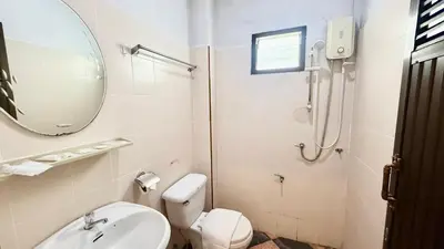 a bathroom with a toilet and a sink and a mirror at Cozy Bay Rawai in Phuket Town