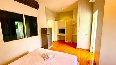a small room with a bed and a kitchen at Cozy Bay Rawai in Phuket Town