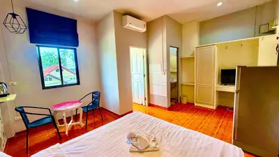 a bedroom with a bed and a table and chairs at Cozy Bay Rawai in Phuket Town