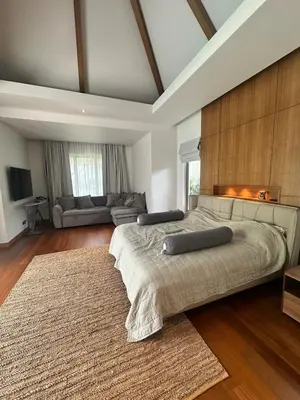 a large bedroom with a large bed and a couch at Anchan Tropicana By Ere in Ban Phru Champa