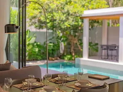 a table with wine glasses on a table in front of a pool at NEW Cozy 3BR Luxury Pool Villa - Villa Nova in Ban Pak Lak