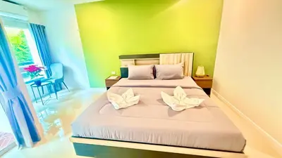 a bedroom with a bed with two flower pillows on it at Abdullah Residence in Patong Beach
