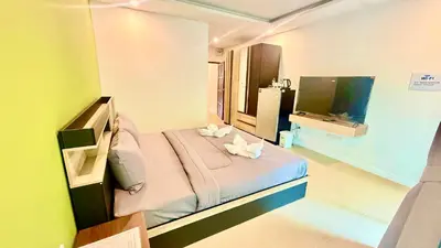 a small bedroom with a bed and a television at Abdullah Residence in Patong Beach