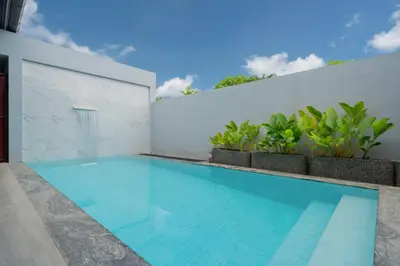 a swimming pool in a house with a white wall at Nicky Luxury Private Pool Villa in BangTao Laguna in Laguna Phuket