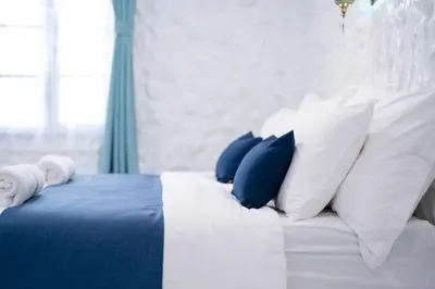 a white bed with blue and white pillows at Sweett Lemon Home in Patong Beach