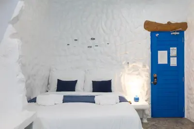 a bedroom with a white bed with a blue door at Sweett Lemon Home in Patong Beach