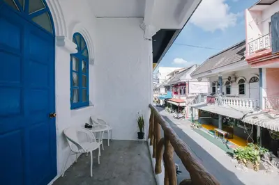 a balcony with chairs and a blue door at Sweett Lemon Home in Patong Beach