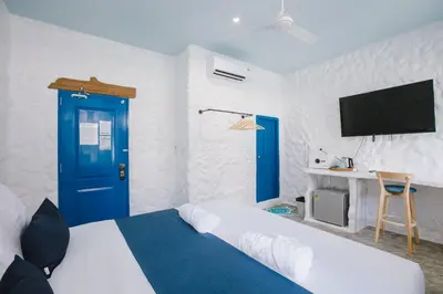 a room with a bed and a blue door and a tv at Sweett Lemon Home in Patong Beach