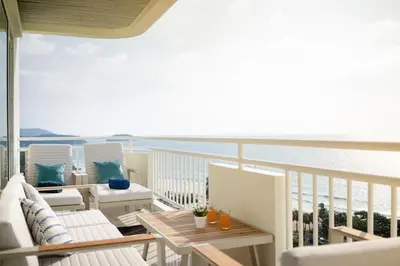 a balcony with chairs and tables and the ocean at Waterfront 16D seaview 2 BR apartment - 5 min walk to Karon beach in Karon Beach