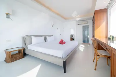 a bedroom with a large white bed and a desk at Waterfront 16D seaview 2 BR apartment - 5 min walk to Karon beach in Karon Beach