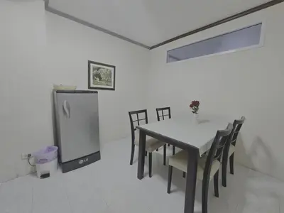 a dining room with a table and a refrigerator at WIVA by Woytuk in Patong Beach