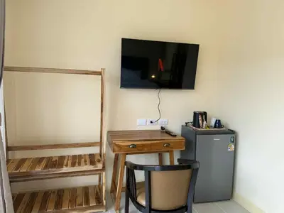 a room with a desk and a television on the wall at Kata Kata Stay in Kata Beach