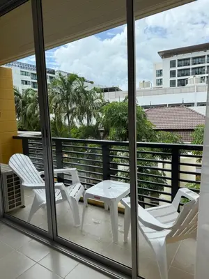 a balcony with white chairs and a table and a view at Kata Kata Stay in Kata Beach