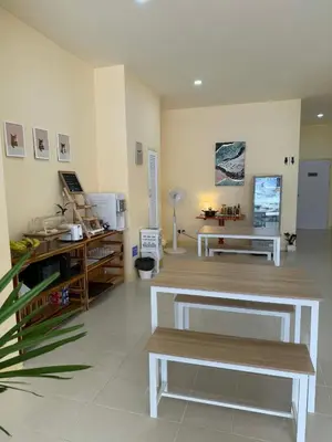 a living room with two benches and a table at Kata Kata Stay in Kata Beach