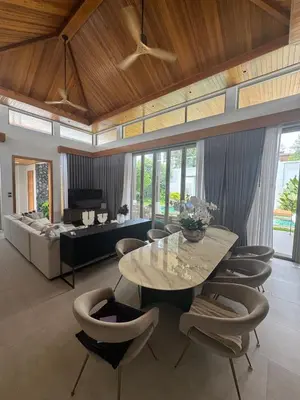 a living room with a table and chairs and a couch at Luxury Botanica Foresta 4 bed in Ban Phru Champa