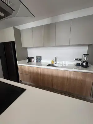 a kitchen with wooden cabinets and a black refrigerator at Luxury Botanica Foresta 4 bed in Ban Phru Champa