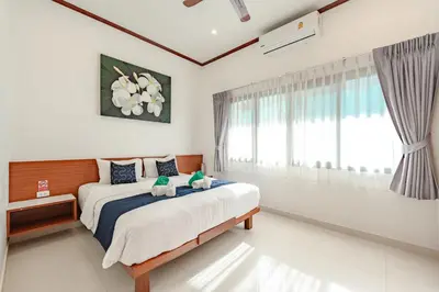 a bedroom with a bed with two stuffed animals on it at Orchid Pool Villa Rawai in Rawai Beach