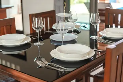 a table with plates and wine glasses on it at Orchid Pool Villa Rawai in Rawai Beach