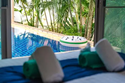 a view of a swimming pool with a surfboard on a bed at Orchid Pool Villa Rawai in Rawai Beach