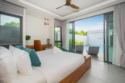 a bedroom with a white bed and a large window at Luxury 3BR Pool Villa Relaxation in BangTao Laguna in Laguna Phuket