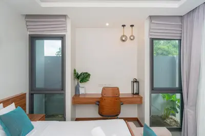 a bedroom with a bed and a desk with windows at Luxury 3BR Pool Villa Relaxation in BangTao Laguna in Laguna Phuket