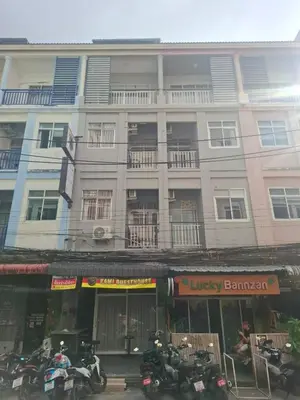 a large building with motorcycles parked in front of it at Kami Guest House Patong in Patong Beach