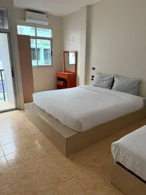 a bedroom with a large white bed and a window at Kami Guest House Patong in Patong Beach