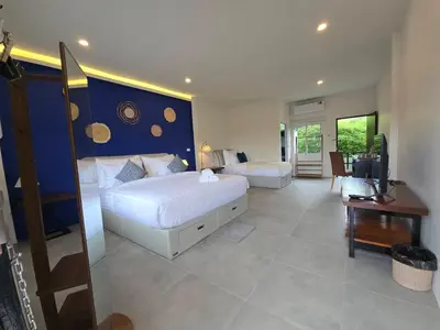 a bedroom with a large bed with a blue wall at The Simple Place - King and Twin in Klong Muang Beach
