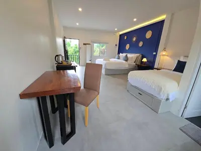 a bedroom with a bed and a desk and a bed at The Simple Place - King and Twin in Klong Muang Beach