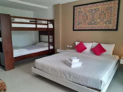 a bedroom with two bunk beds with red pillows at Island Patongbeach Apartments in Patong Beach