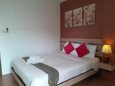 a bedroom with a bed with red and white pillows at Island Patongbeach Apartments in Patong Beach