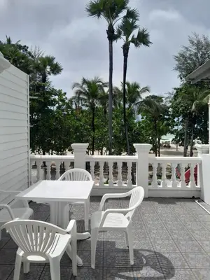 a white table and chairs on a patio with palm trees at Island Patongbeach Apartments in Patong Beach