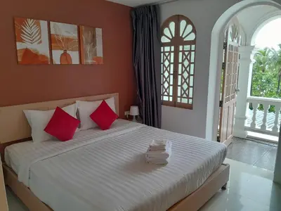 a bedroom with a large bed with red pillows at Island Patongbeach Apartments in Patong Beach