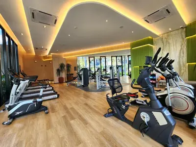 a gym with several treadmills and exercise bikes at Cozy Palm Haven apartment in Kathu