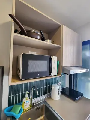 a kitchen counter with a microwave and a sink at Cozy Palm Haven apartment in Kathu