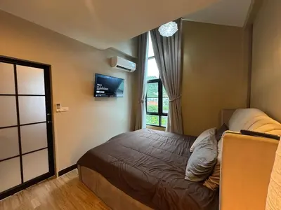a bedroom with a bed and a tv and a window at Rare Find Penthouse with Private Office and Jungle Mountrain Views in Kamala Beach