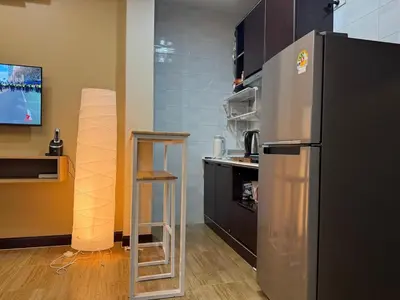 a kitchen with a stainless steel refrigerator and a ladder at Rare Find Penthouse with Private Office and Jungle Mountrain Views in Kamala Beach