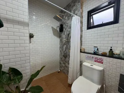 a white bathroom with a shower and a toilet at Rare Find Penthouse with Private Office and Jungle Mountrain Views in Kamala Beach