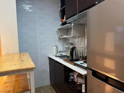 a small kitchen with a stainless steel refrigerator at Rare Find Penthouse with Private Office and Jungle Mountrain Views in Kamala Beach