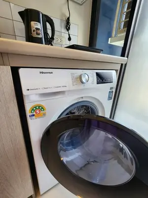 a washer and dryer sitting under a counter at Cozy Minimalist room in Kathu