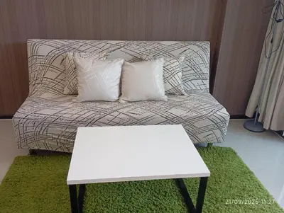 a white couch with two pillows and a table at The Title Rawai Beach Front 1bdr in Rawai Beach