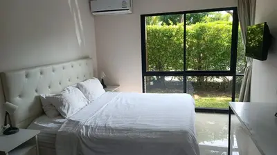 a bedroom with a white bed and a window at The Title Rawai Beach Front 1bdr in Rawai Beach