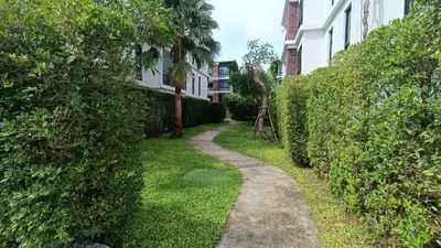 a path in a yard next to a building at The Title Rawai Beach Front 1bdr in Rawai Beach